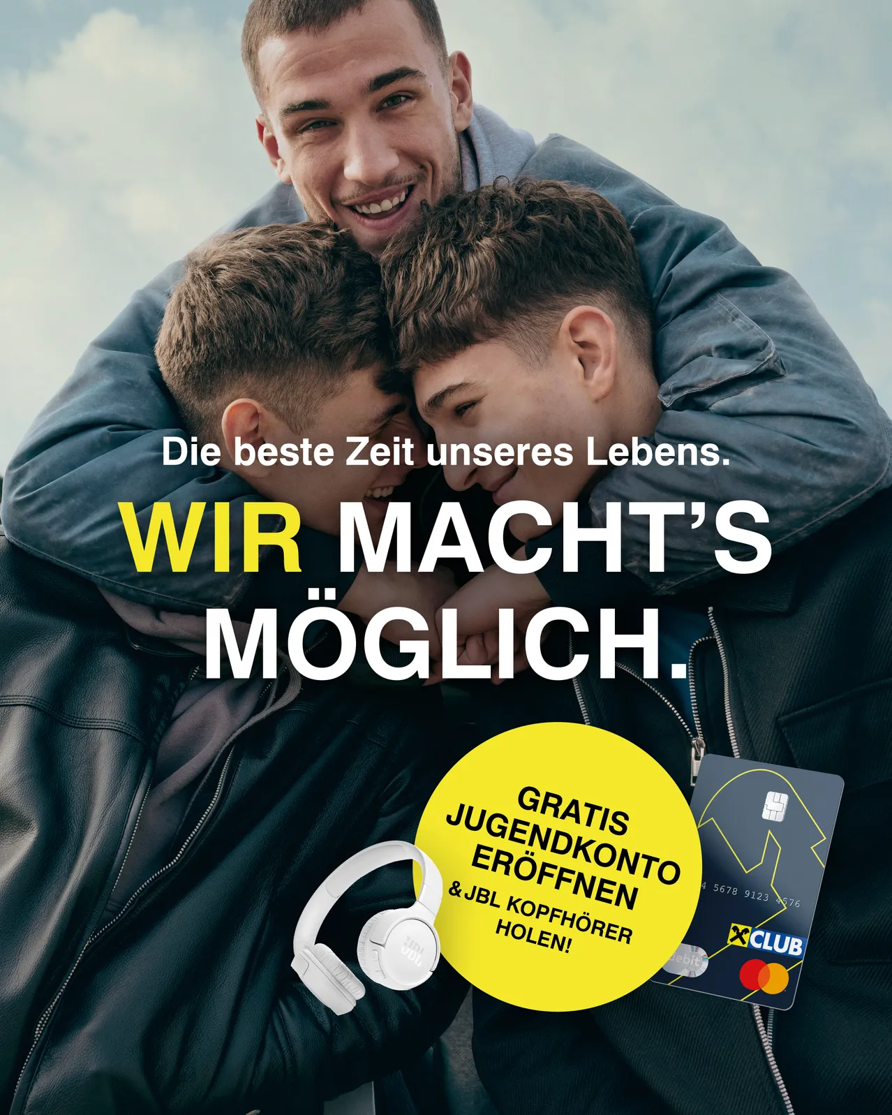 Zwei junge Männer umarmen sich und lächeln. Der Text lautet 'Die beste Zeit unseres Lebens. WIR MACHEN'S MÖGLICH.' Es gibt auch einen gelben Kreis mit Kopfhörern und eine Karte, die 'Gratis Jugendkonto und JBL Kopfhörer' sagt.