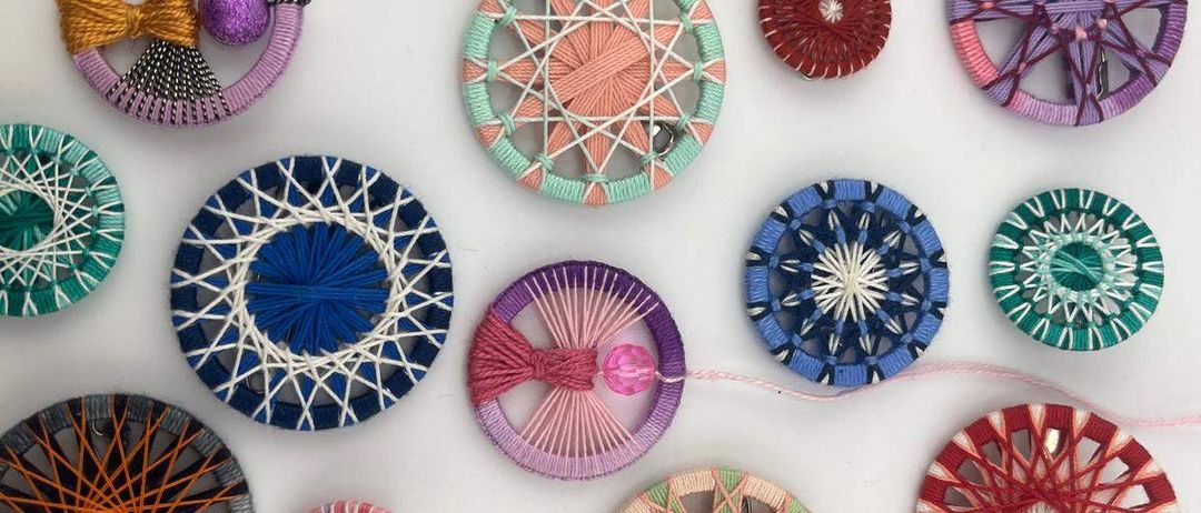 Eine Sammlung von farbenfrohen kreisförmigen Objekten, möglicherweise handgefertigt, mit komplizierten Mustern und Designs, auf einem weißen Hintergrund ausgestellt.