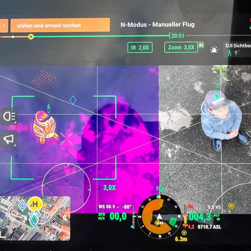 Ein Bildschirm zeigt ein Infrarotbild, eine Karte und Flugdaten. Das Infrarotbild zeigt eine Person mit einem grünen Marker. Flugdaten umfassen Höhe, Geschwindigkeit und Richtung. Die Karte zeigt einen Standort mit einem hervorgehobenen Bereich.