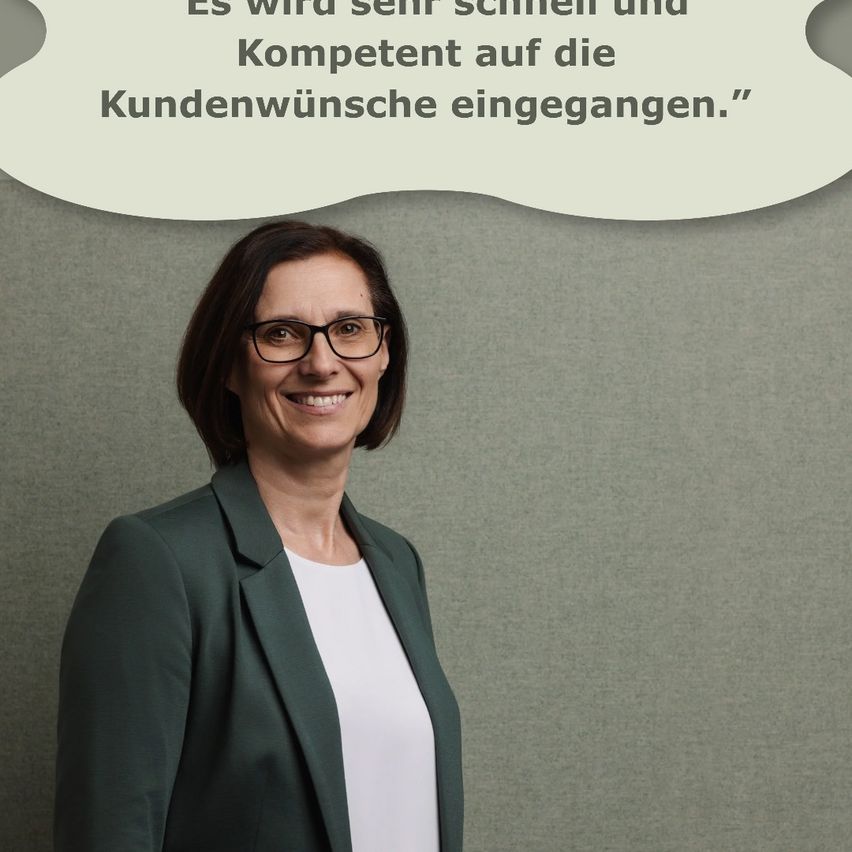 Eine lächelnde Frau mit Brille und grünem Blazer steht vor einer strukturierten grauen Wand. Über ihr befindet sich eine weiße Sprechblase mit dem Zitat: 'Wir werden sehr schnell und kompetent auf die Kundenwünsche eingehen.'