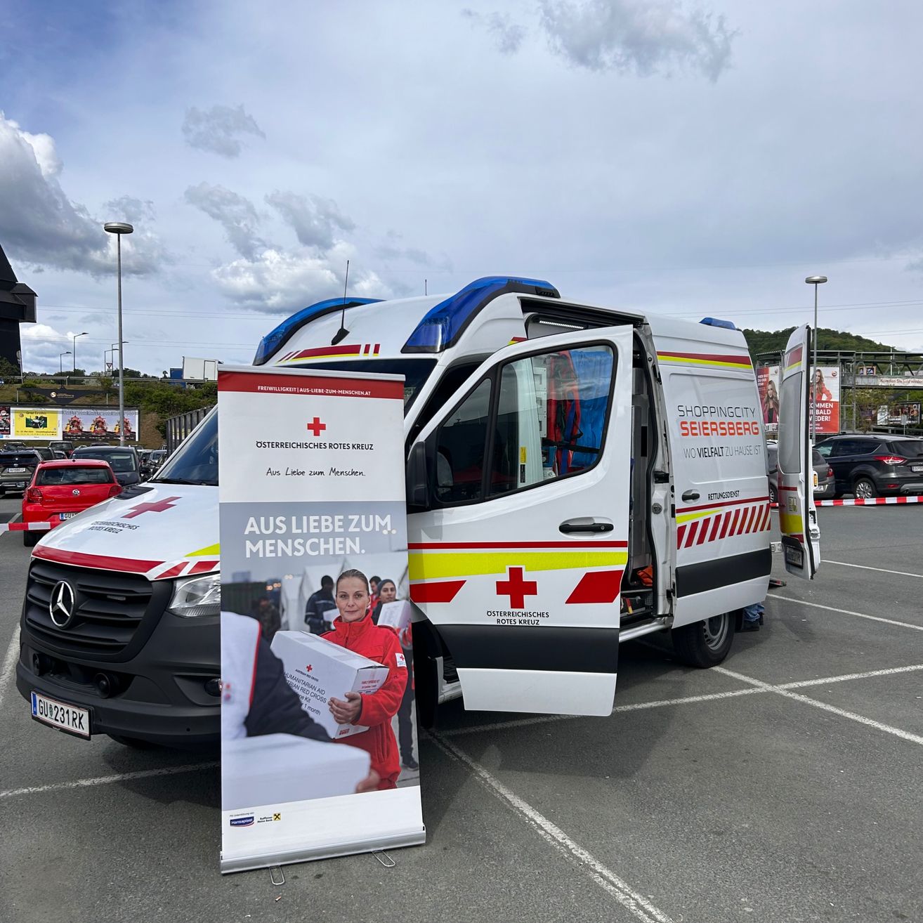 Bild enthält, Logo, Person, Car, Transportation, Vehicle, Machine, Wheel, Symbol, Face, Advertisement