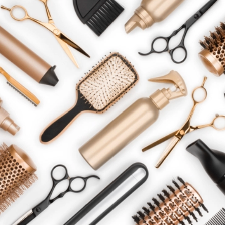 Eine Sammlung von goldenen und schwarzen Haarstyling-Werkzeugen auf weißem Hintergrund. Beinhaltet Bürsten, Scheren, Sprühflasche und Kämme.
