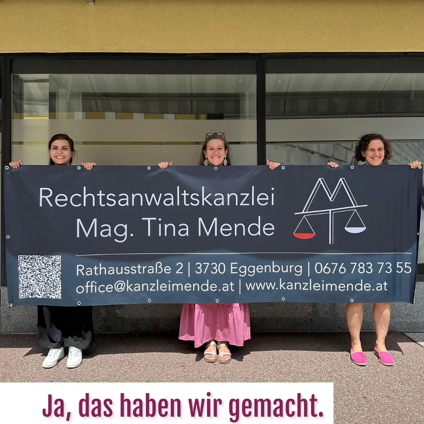 Drei Frauen halten ein Banner mit dem Logo einer Anwaltskanzlei, Büroadresse und Kontaktdaten. Sie stehen vor einem Gebäude mit einem Glasfenster. Unten auf dem Banner steht 'Ja, das haben wir gemacht'.