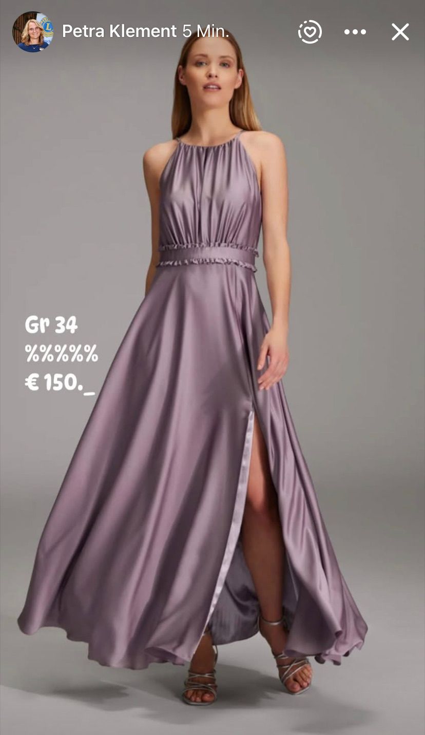 A woman stands in a purple, long, sleeveless dress with a high slit. The dress has a ruffled neckline. The text 'Gr 34', '%%%', and '€ 150' is superimposed.