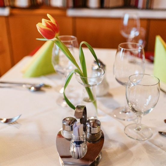 Bild enthält, Furniture, Table, Dining Table, Tabletop, Cutlery, Glass, Flower, Flower Arrangement, Dining Room, Spoon