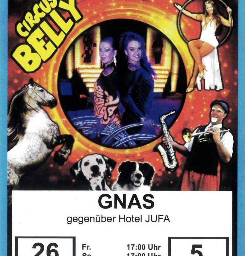 Ein Poster für Circus Belly mit einer Frau und einem Mann mit Musikinstrumenten, einem Pferd und Hunden. Es steht Gnas, gegenüber vom Hotel Jufa, mit Datum und Uhrzeit.