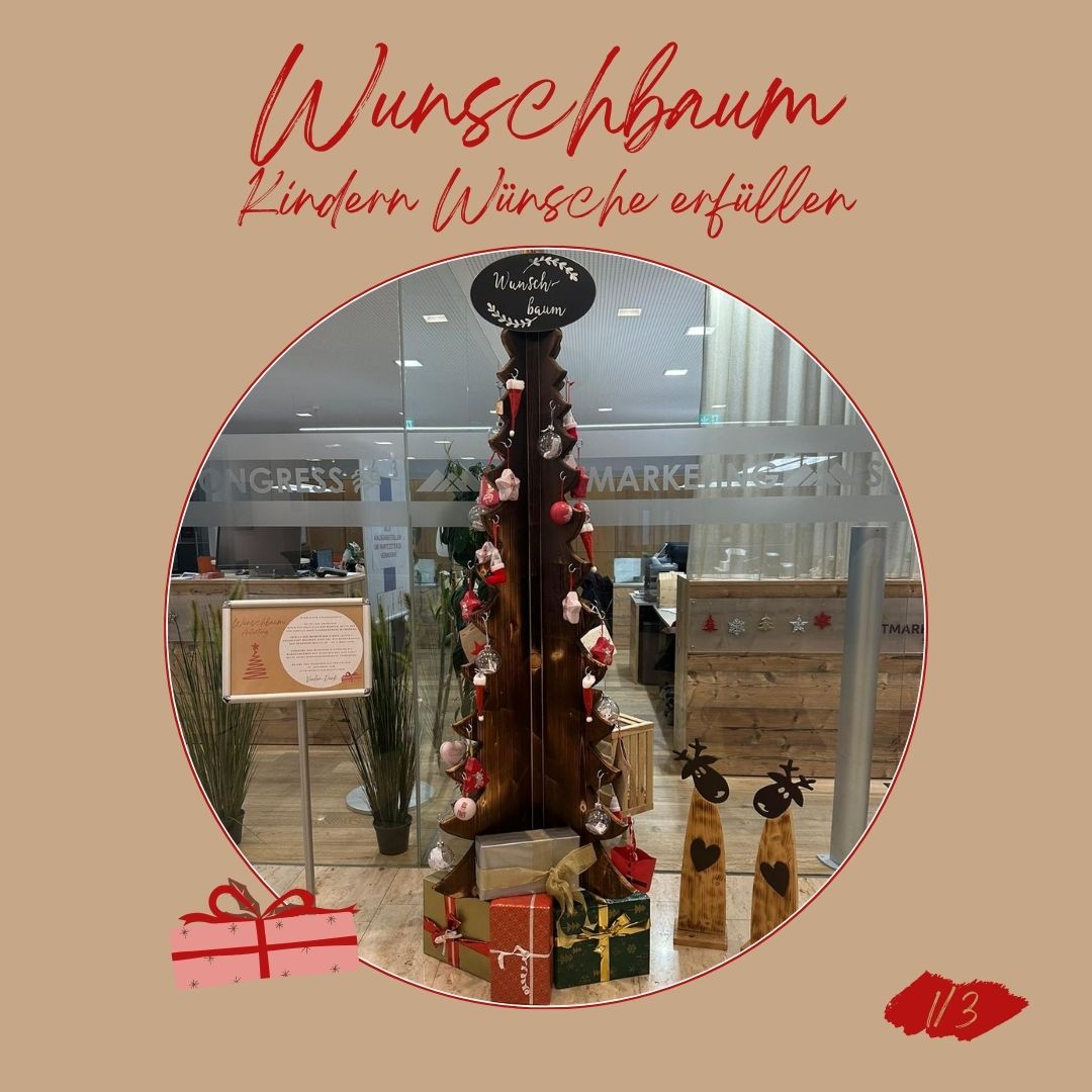 Ein geschmückter Weihnachtsbaum steht in einem Geschäft mit Geschenken darum herum. Ein Schild lautet 'Wunschbaum Kinderwunsche erfullen'.