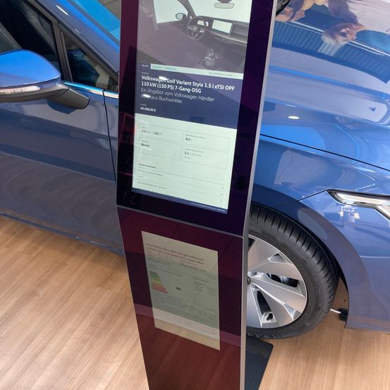 Ein Informationsdisplay für den Volkswagen Golf Variant Style, mit einem blauen Auto im Hintergrund, zeigt Details zu Leistung und Kraftstoffverbrauch an.