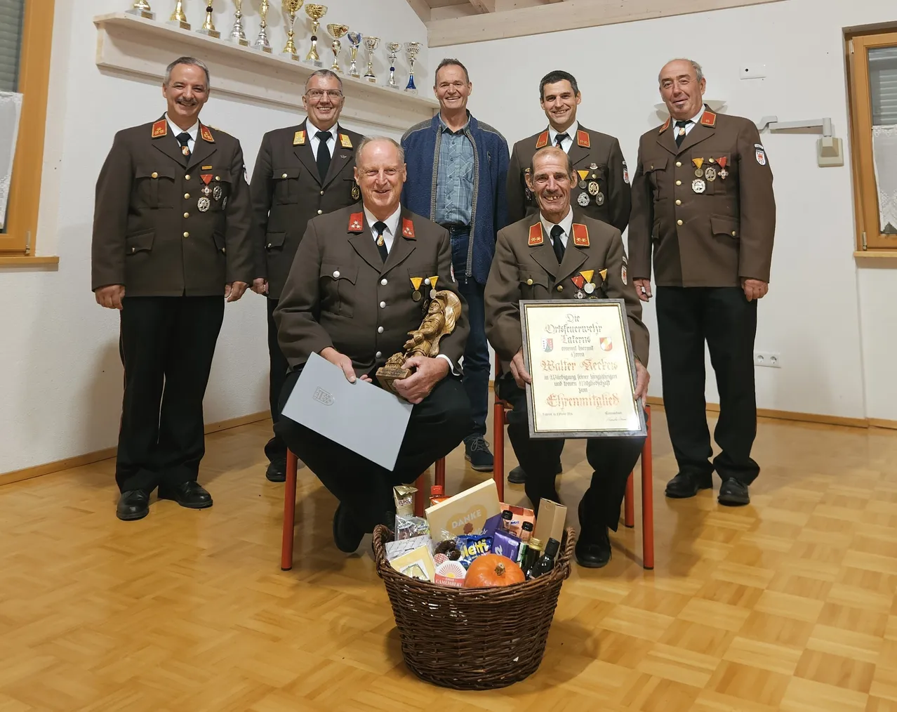 Eine Gruppe von Männern in Militäruniformen posiert für ein Foto. Ein Mann hält eine Trophäe und ein Zertifikat.
