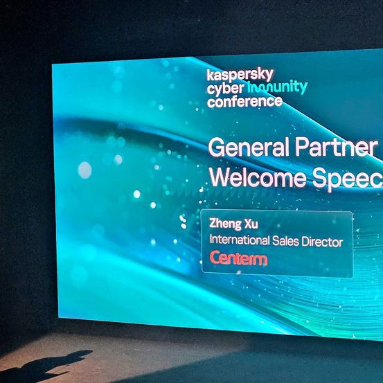 Blauer Bildschirm mit 'General Partner Welcome Speech' und 'Zheng Xu, Internationaler Vertriebsdirektor, Centerm'. Im Hintergrund ist das Logo der Kaspersky Cyber Immunity Conference zu sehen.