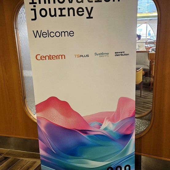 Ein Banner für 'Innovation Journey' heißt Besucher willkommen. Es zeigt ein farbenfrohes abstraktes Design mit Logos für 'Centerm', 'Ts Plus' und 'Systeme Electric'. Dahinter putzt eine Person ein bogenförmiges Fenster.