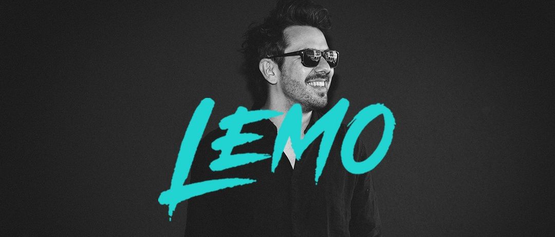 Ein Mann mit Sonnenbrille und schwarzem Hemd steht lächelnd vor einem dunklen Hintergrund. Das Wort LEMO ist in türkisfarbener Graffiti-Schrift geschrieben.