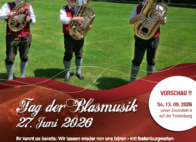 Drei Musiker spielen Tubas auf einem Rasenfeld. Ein rot-weißes Banner sagt 'Tag der Blasmusik' und '27. Juni 2026'. Es zeigt ein Haus im Hintergrund.