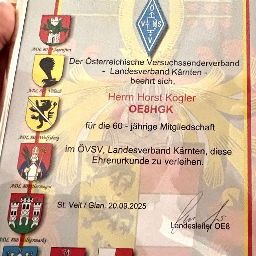 Ein Zertifikat ehrt Horst Kogler für 60 Jahre Mitgliedschaft im Österreichischen Amateurfunkverband. Es enthält verschiedene Embleme und eine Unterschrift. Datum 20.09.2025.