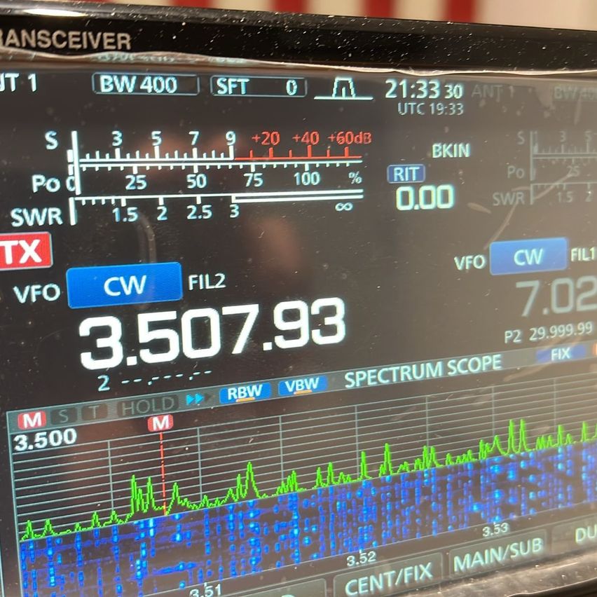 Ein Transceiver-Bildschirm zeigt eine Frequenz von 3.507,93 MHz mit einem Signalpegel von 25. Der Bildschirm zeigt Spektrumbereich, Signalpegel und SWR-Einstellungen.