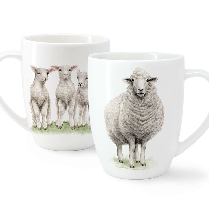 Zwei weiße Kaffeebecher mit Schafsdesigns. Ein Becher zeigt eine Gruppe von drei Lämmern in einer Reihe, der andere zeigt ein einzelnes Schaf im Stehen.