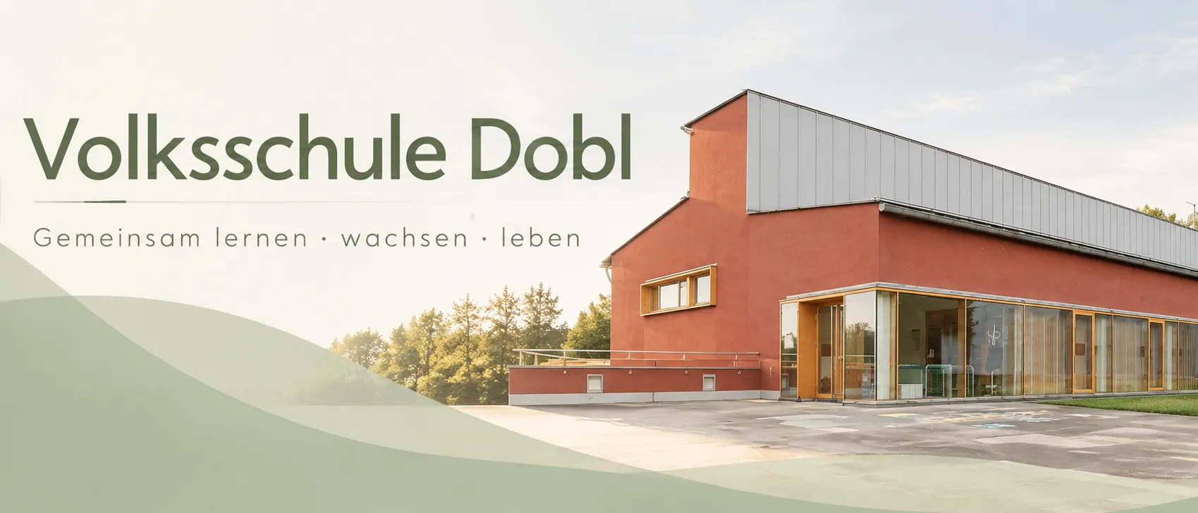 Ein leuchtend rotes Gebäude mit modernem Design, beschriftet mit 'Volksschule Dobl', steht prominent vor einem Hintergrund aus Bäumen und klarem Himmel.