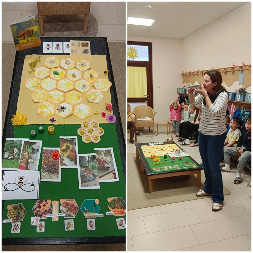 Ein Klassenzimmer mit einer bienenthematischen Tafel und einer Frau, die zu Schülern spricht. Ein Tisch hat ein Honigwaben-Setup, Bücher und Bilder von Bienen und Honigwaben.