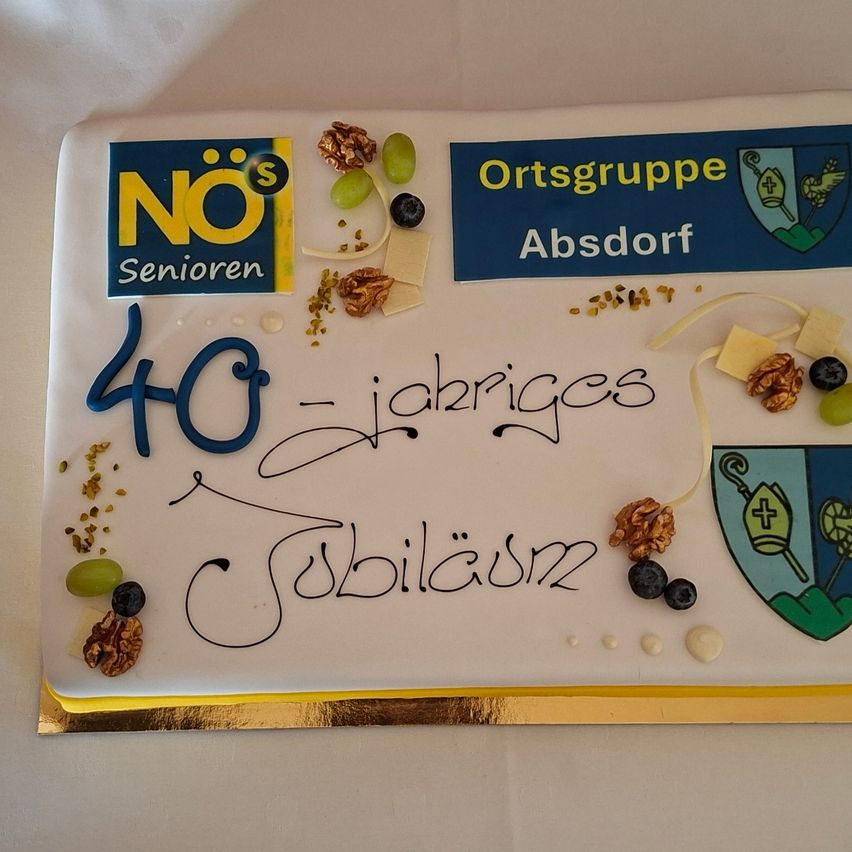 Ein Kuchen zum 40-jährigen Jubiläum, mit verschiedenen Lebensmitteln und einem Logo von NOs Senioren, einer deutschen Organisation. Es steht '40 Jahre' und 'Jubilaum'.