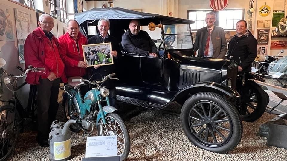 Bild enthält, Tie, Adult, Male, Man, Person, Antique Car, Model T, Handbag, Motorcycle, Glasses