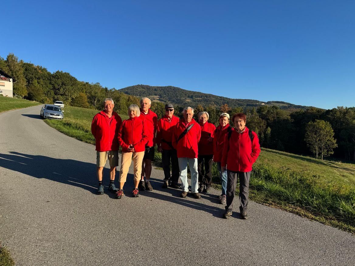 Eine Gruppe von Menschen in roten Jacken steht am Straßenrand.