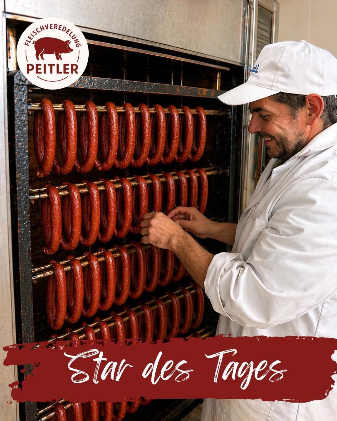 Ein Mann in einer weißen Jacke und Kappe arbeitet in einer Wurstfabrik und ordnet Würste in Regalen an. Der Markenname Peitler ist oben links sichtbar. Der Slogan Star des Tages steht unten.