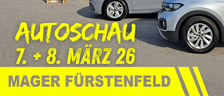 Volkswagen dealership with cars parked in front. The text reads 'AUTOSCHAU 7 + 8. MÄRZ 26' and 'MAGER FÜRSTENFELD'. A white umbrella stands beside a parked car.