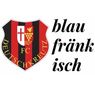 Ein Wappen eines Fußballvereins mit einem Schild, das schwarze und rote Streifen, ein Kreuz und ein Traubendesign aufweist. Der Text lautet 'blau frank isch'.