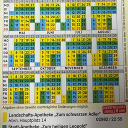 Das Bild zeigt einen Kalender für das Jahr 2025 mit den Öffnungszeiten zweier Apotheken. Die erste Apotheke, 'Zum schwarzen Adler,' befindet sich am Hauptplatz 14 und ist unter 02982/22 55 erreichbar. Die zweite Apotheke, 'Zum heiligen Leopold,' hat einen nicht näher spezifizierten Standort. Der Kalender umfasst die Monate von August 2024 bis Dezember 2025.