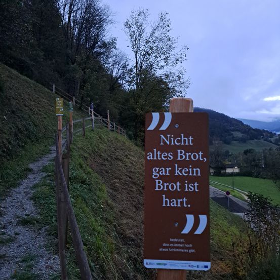 Ein Schild am Weg sagt: 'Nicht alles Brot ist hart, nicht alles Brot ist alt, es gibt immer noch etwas Gutes'.