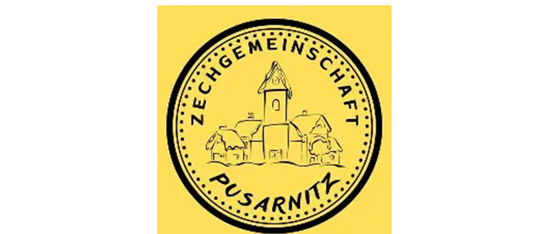 Ein gelbes kreisförmiges Emblem mit einem kleinen Turm mit einer Glocke oben und einer Reihe von Häusern darunter, alles umgeben von dem Text 'ZECHGEMEINSCHAFT PUSARNITZ'.