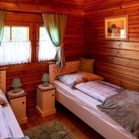 Bild enthält, Indoors, Interior Design, Hardwood, Wood, Stained Wood, Bed, Rug, Wood Panels, Painting, Lamp