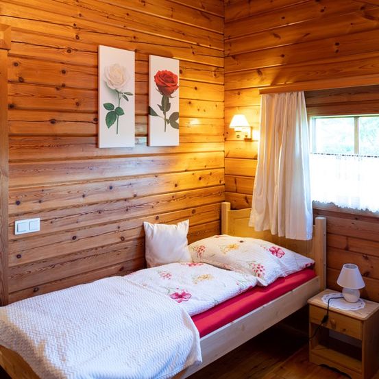 Bild enthält, Indoors, Interior Design, Wood Panels, Hardwood, Wood, Stained Wood, Bed, Furniture, Lamp, Rug