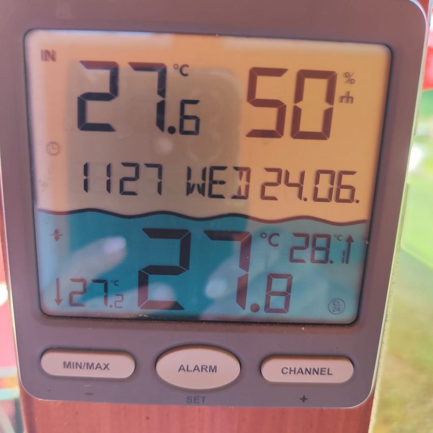 Ein digitaler Display zeigt Temperatur bei 27,6°C, Luftfeuchtigkeit bei 50%, Datum 12/24/06 und Wassertemperatur bei 27,1°C. Tasten mit den Aufschriften MIN/MAX, ALARM, CHANNEL und SET.