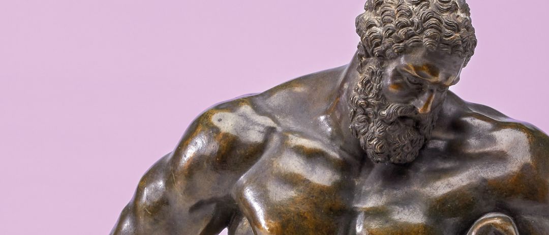 Eine bronzene Statue eines bärtigen, muskulösen Mannes mit einem Blatt an der Taille, auf einem rosa Hintergrund stehend.