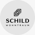 Das Logo für Schild Wohntraum, mit einem stilisierten Buchstaben G über dem Markennamen in einem weißen Kreis.