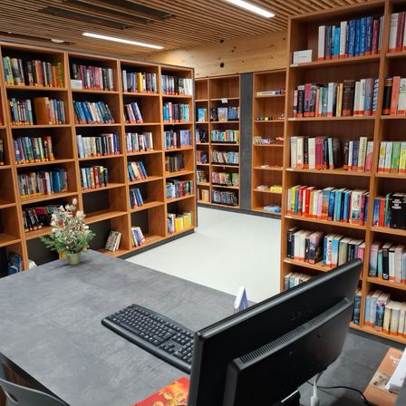 Bild enthält, Furniture, Bookcase, Computer Keyboard, Hardware, Architecture, Building, Monitor, Indoors, Library, Chair