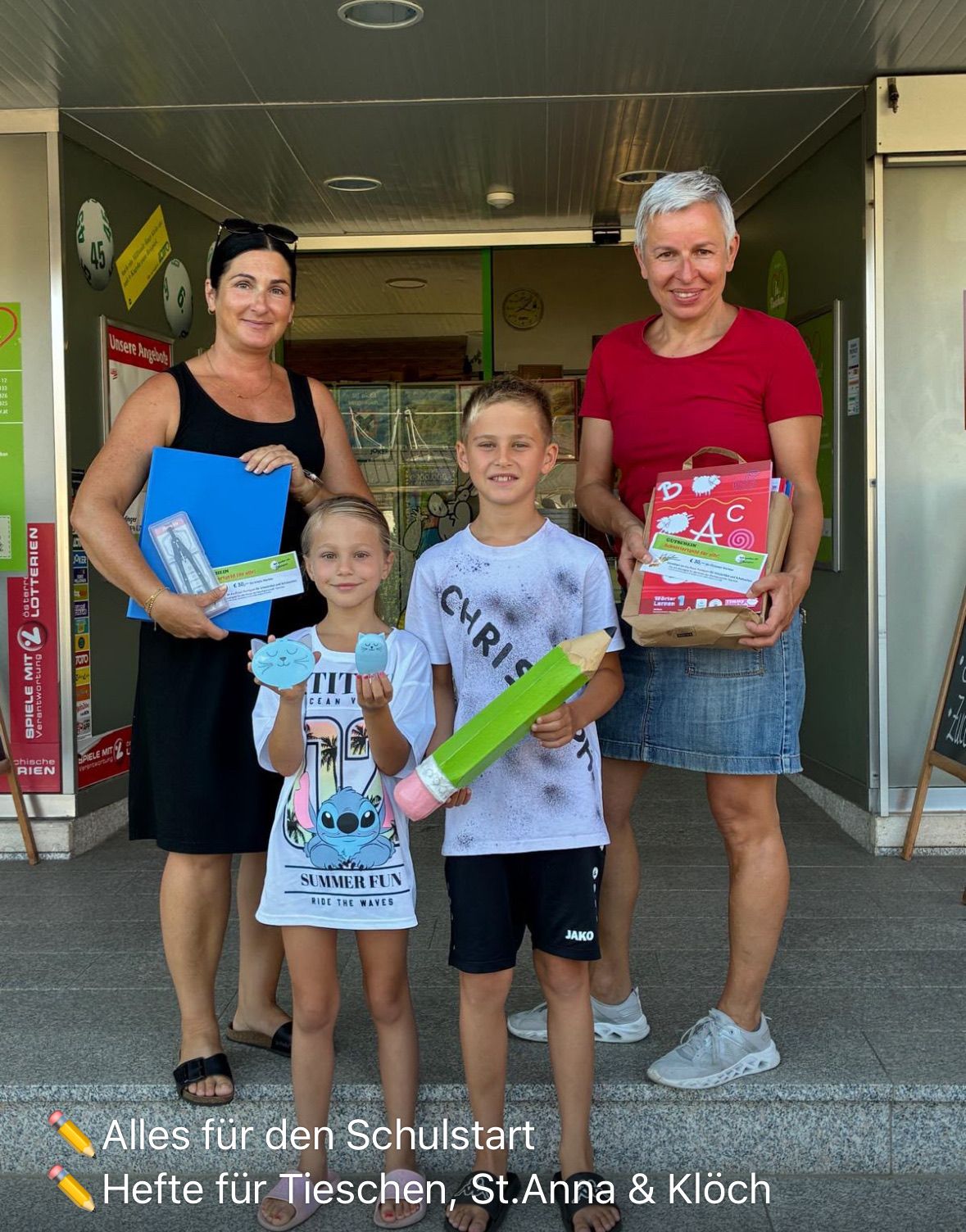 Zwei Frauen und zwei Kinder stehen vor einem Geschäft und halten einen Stift und ein Buch. Die Frau auf der linken Seite hält eine blaue Mappe und eine Karte, während die Frau auf der rechten Seite einen braunen Papierbeutel hält. Die Kinder halten einen Stift und ein kleines Objekt.