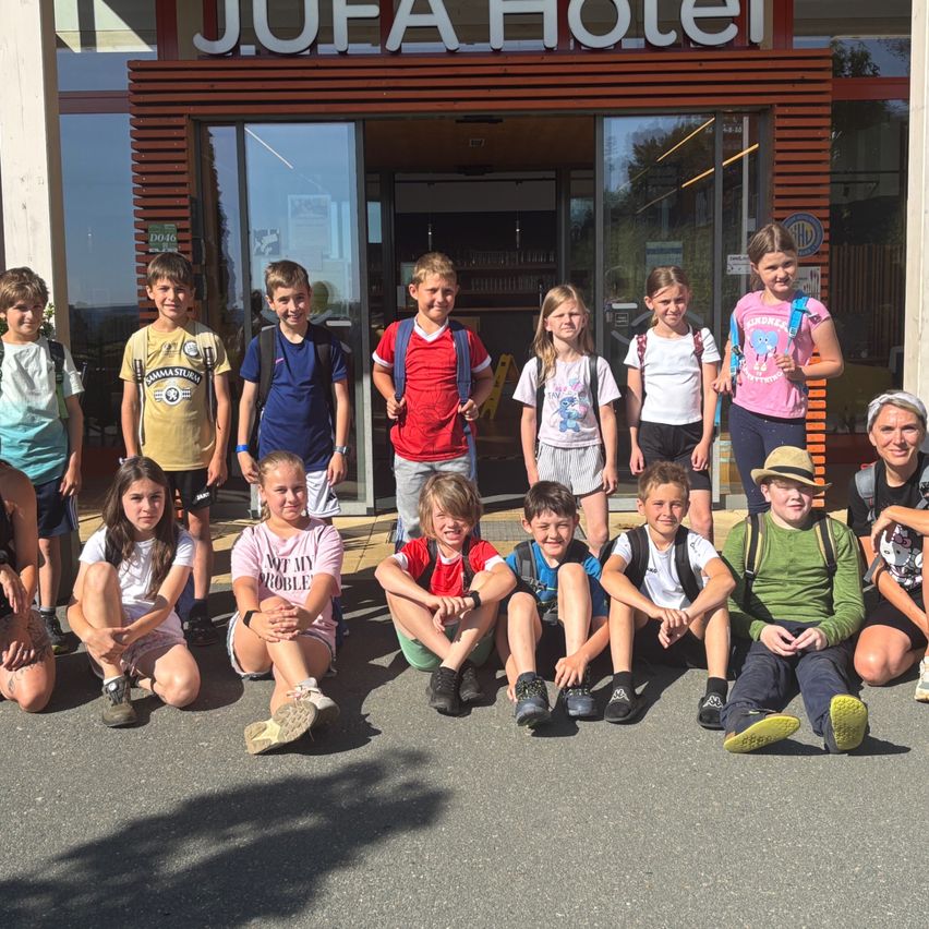 Gruppe von Kindern und Teenagern posiert für ein Foto vor dem J.U.E.A Hotel.