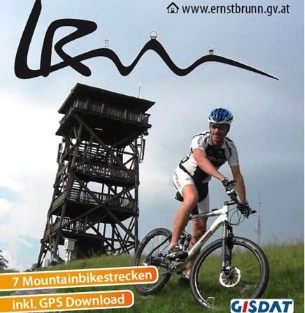 Ein Plakat bewirbt Mountainbike Arena Leiser Berge - Ernstbrunn mit einem Mountainbiker, einem Aussichtsturm und sieben Mountainbike-Strecken mit GPS-Download.