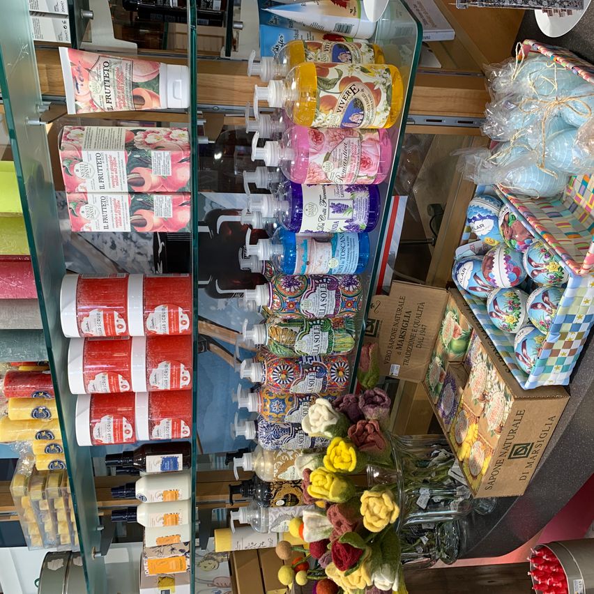 Ein Ladendisplay mit verschiedenen Produkten auf Glasregalen, darunter Flüssigseife, Badeprodukte und dekorative Eier.