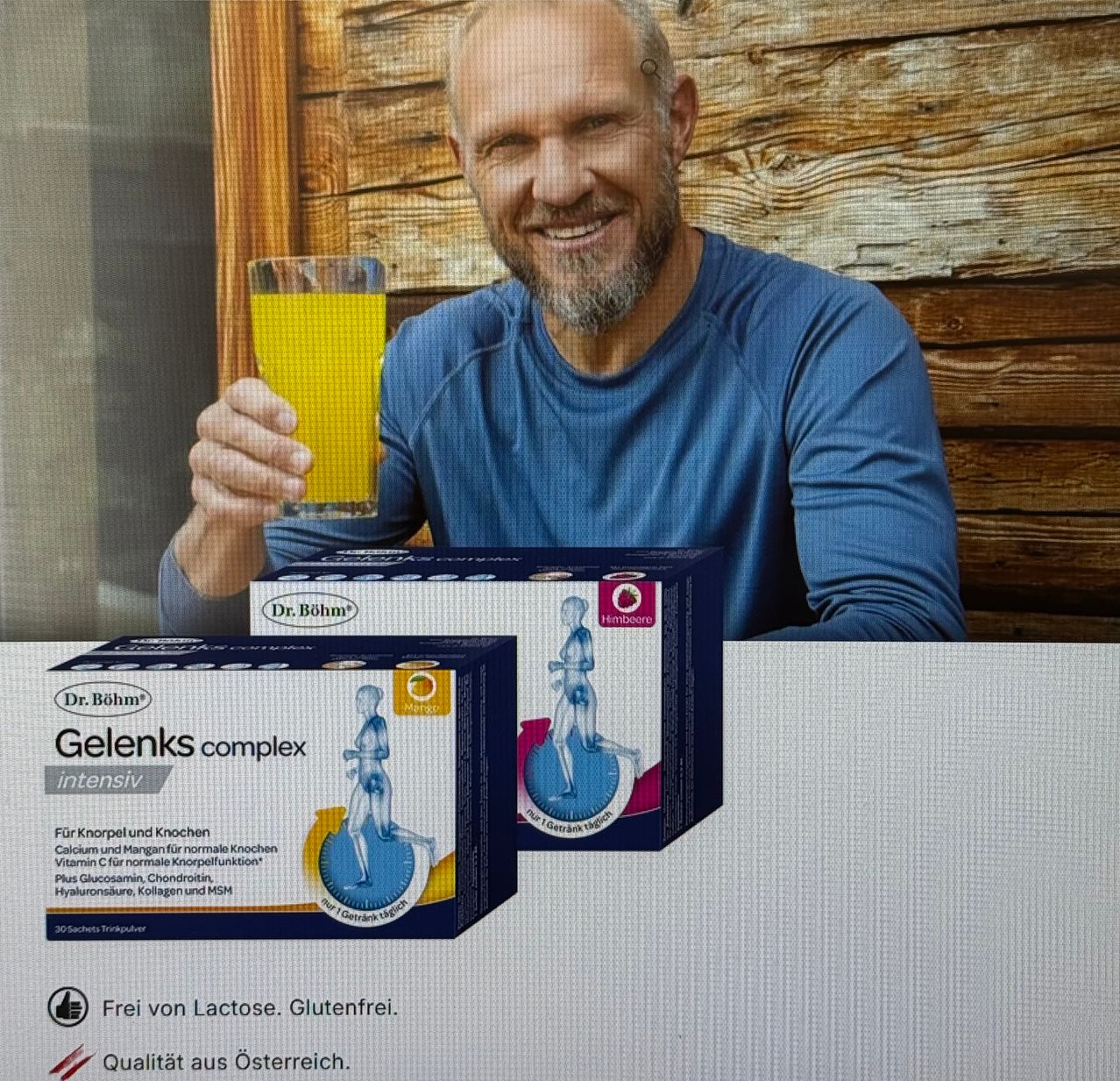 A man is holding a glass of orange juice. He is smiling and appears to be posing for a photo. Two boxes of 'Dr. Böhm Gelenks complex intensiv' supplements are visible in front of him. The boxes contain a mix of vitamins and minerals for joint health.