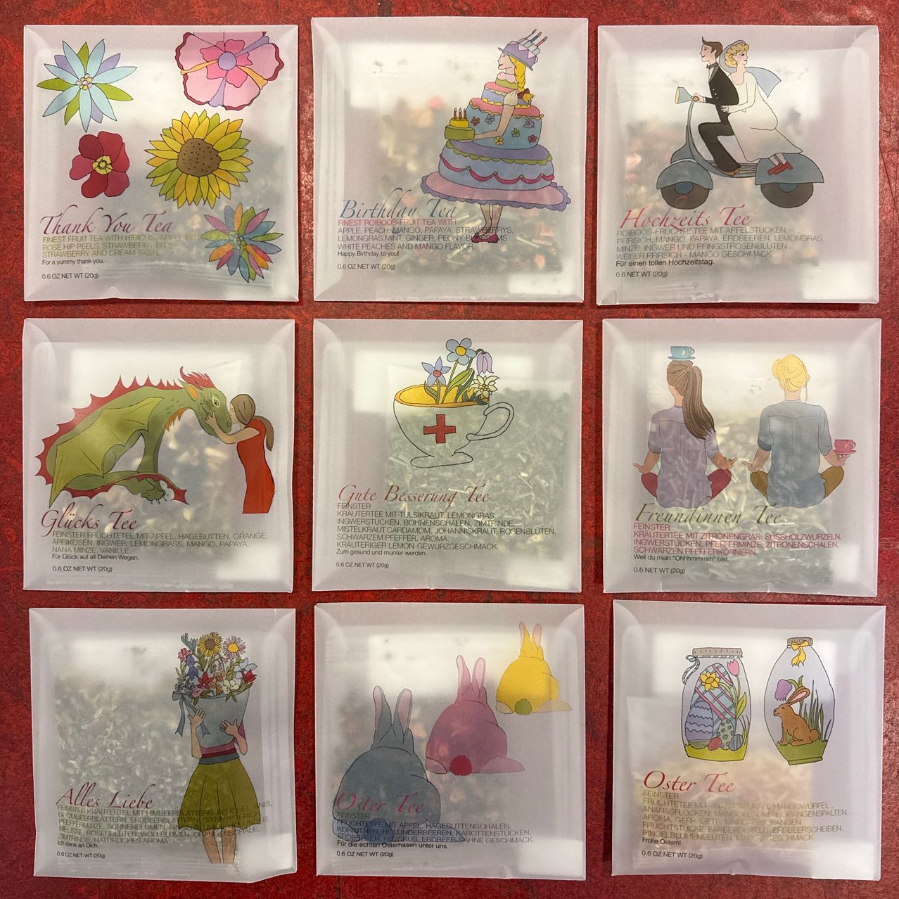 Eine Sammlung von Teebeuteln in durchsichtiger Verpackung, jeder mit einer einzigartigen Illustration und Text auf der Vorderseite. Sie umfassen 'Danke Tee', 'Geburtstags Tee', 'Hochzeits Tee', 'Glucks Tee', 'Frauentee' und 'Alle Liebe'.