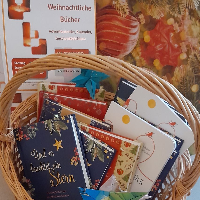 Ein Korb aus Weide gefüllt mit Büchern und einem blauen Origami-Stern mit einem Schild im Hintergrund, das 'Weihnachtliche Bücher' und ein Datum vom November 2025 zeigt.