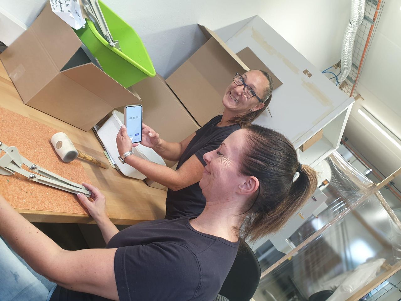 Bild enthält, Furniture, Table, Adult, Female, Person, Woman, Desk, Mobile Phone, Phone, Text