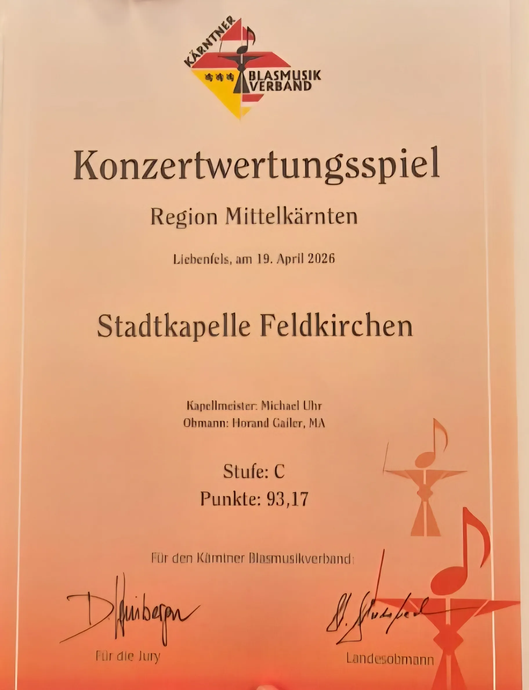 Ein Zertifikat für ein Konzertbewertungsspiel in der Region Mittelkärnten, das am 19. April 2026 in der Stadtkapelle Feldkirchen stattfand. Der Bandleiter ist Michael Uhr und der Dirigent ist Horand Gäller. Die Band erhielt die Note C und 93,17 Punkte.