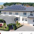 Gasthaus Kaufmann, ein weißes Gebäude mit Solarpanelen auf dem Dach, befindet sich in Wetzelsdorf 14, 8083 Jagerberg. Das Bild zeigt auch einen Teller mit Essen.