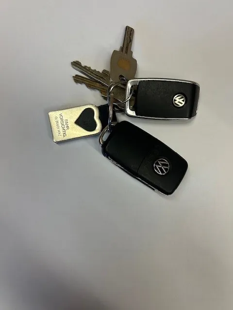 Ein Satz Schlüssel mit Volkswagen-Logo auf weißem Hintergrund. Die Schlüssel sind schwarz mit silbernen und goldenen Akzenten.