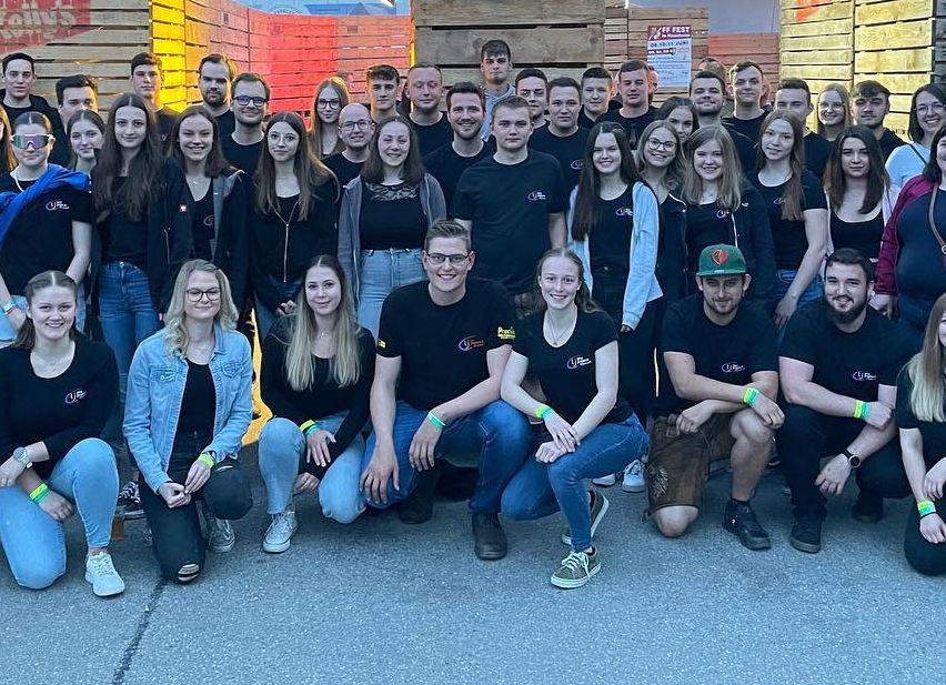 Bild enthält, College, Groupshot, Person, Adult, Male, Man, Shoe, Glasses, Wristwatch, Scoreboard