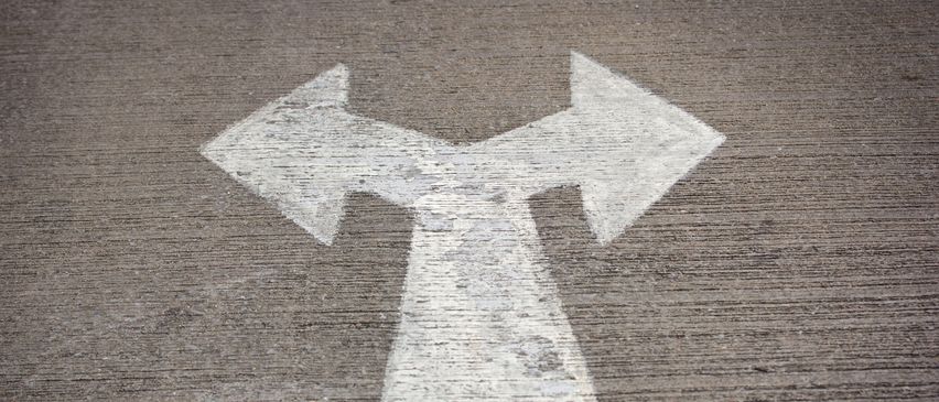 Ein weißer Pfeil, der nach oben zeigt, auf einer grauen Oberfläche, ähnlich einem Zebrastreifen-Schild.